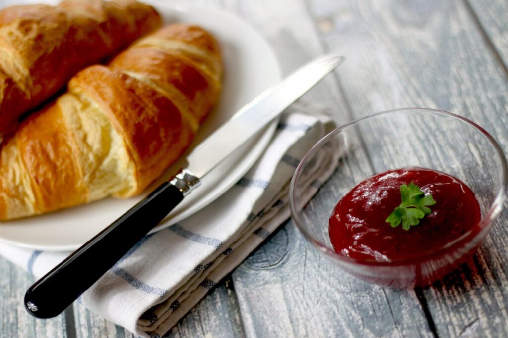 Frühstück mit Croissant, Marmelade und frischen Backwaren